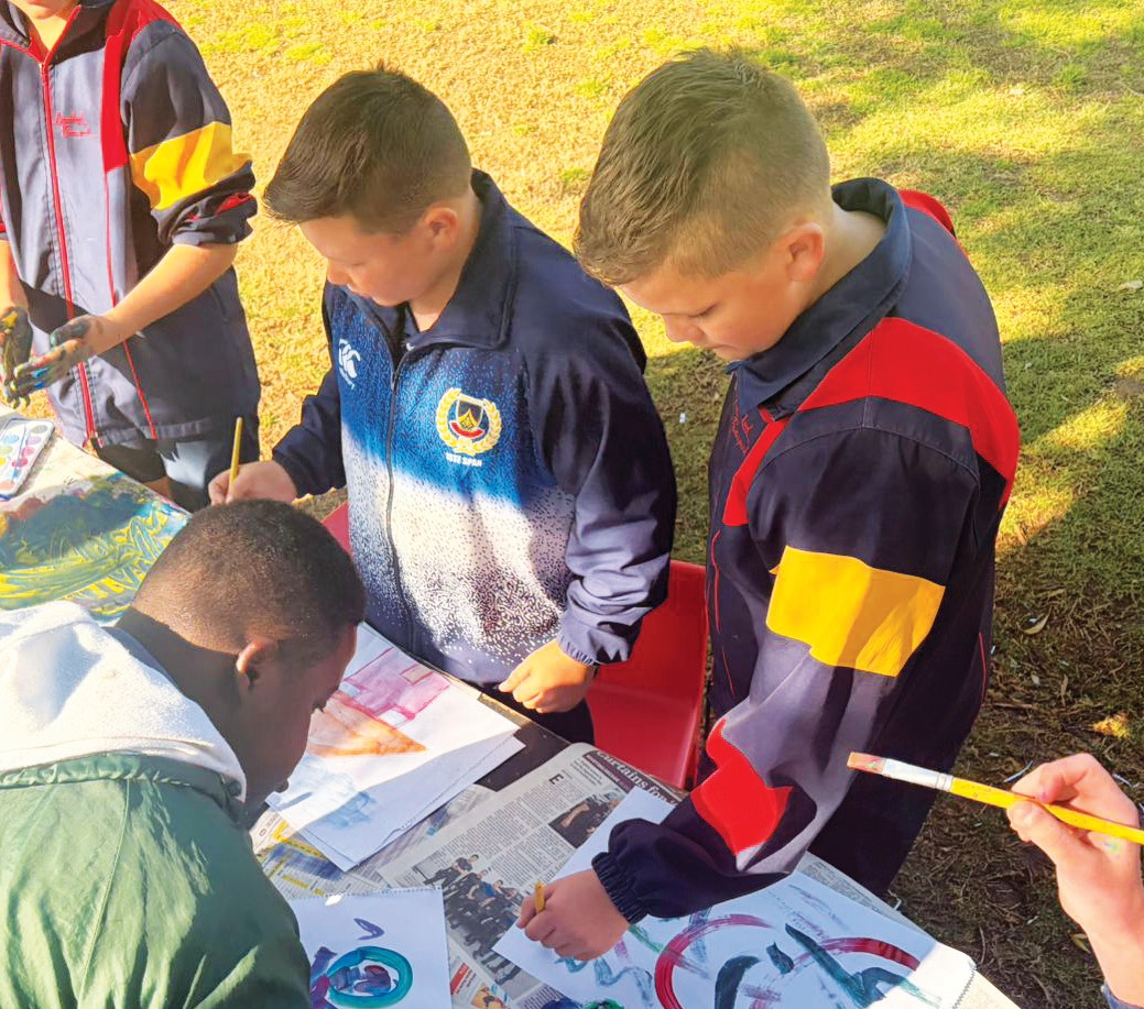 Lekker verf, lag en kuier – leerders van die twee skole geniet die dag saam.